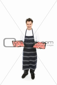Butcher with trays of meat