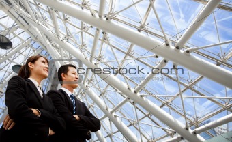 Two business people stand in modern office