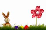 easter bunny behind grass with drapery flower and easter eggs