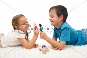 Happy kids - boy and girl - playing on the floor
