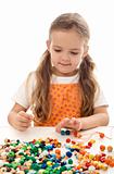 Little girl playing with string and beads