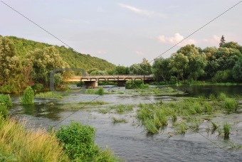 Landscape: the river, the bridge through the river and wood