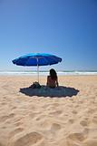 blue parasol with woman sit on towel