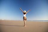 happy female with hat walking at beach