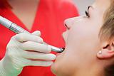 Image of young lady with dentist over her checking oral cavity 
