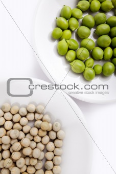 Fresh and dried green peas on plate