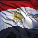 Flag of Egypt, fluttering in the breeze, backlit rising sun