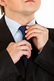 Businessman adjusting his  tie. Close-up. 
