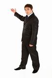 Serious young businessman pointing  in corner
