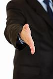 Businessman stretches out hand for handshake. Close-up. 

