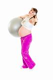Happy beautiful pregnant woman holding fitness ball and showing thumbs up gesture
