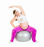 Smiling beautiful pregnant woman doing exercises on fitness ball
