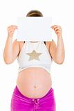 Pregnant woman holding empty white  paper in front of her face
