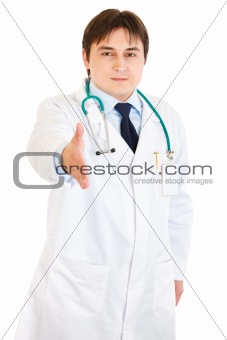 Friendly  medical doctor stretches out hand for handshake

