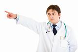 Confident medical doctor pointing finger at something

