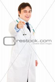 Smiling young medical doctor pointing finger at you
