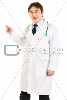 Smiling medical doctor pointing finger at something
