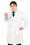Serious medical doctor holding up stethoscope
