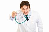 Fierce medical doctor holding up stethoscope
