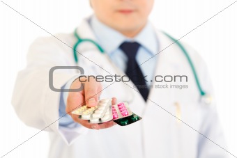 Doctors hand holding packs of pills. Close-up.
