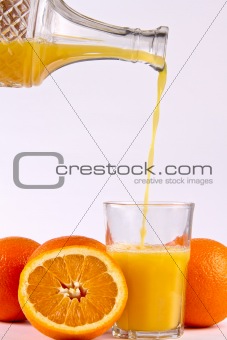 Orange juice pouring into glass.