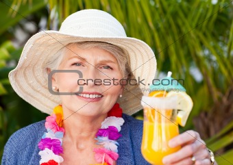 Retired woman drinking a cocktail under the sun