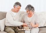 Couple playing chess on their sofa