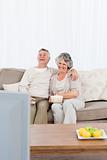 Mature couple watching tv in their living room 