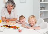 Children cooking with their grandmother at home
