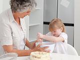 Girl baking with her grandmother at home