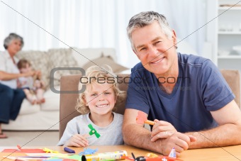 Little boy drawing with his grand father