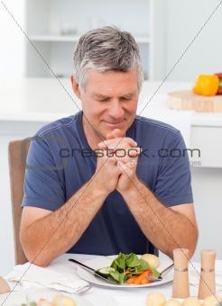 Man praying at the table