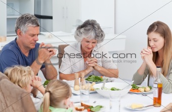Family praying at the table