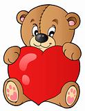Cute teddy bear holding heart
