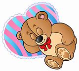 Teddy bear on heart shaped pillow