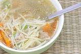 Broth soup with spoon and vegetable