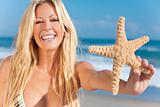 Beautiful Girl Smiling on Beach With Starfish