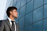 Young businessman looking good expectations on modern building background
