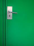 Metal door handle on green