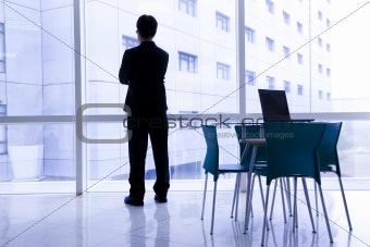 Businessman standing in the  office and laptop on the table