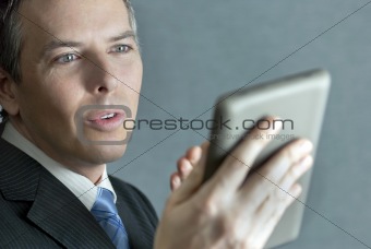 Confident Businessman Gesturing To Tablet Computer 
