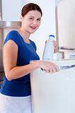 woman taking a bottle of milk from the fridge