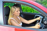 beautiful woman driver in red shiny car outdoors smiling
