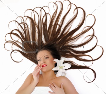 Beautiful spa woman with long healthy hair lying on the floor
