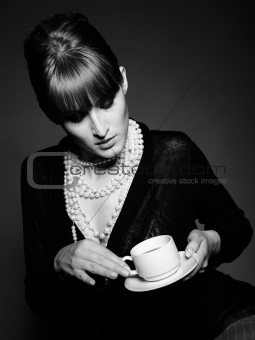 Beautiful retro woman with red lips holding cup of coffee. black