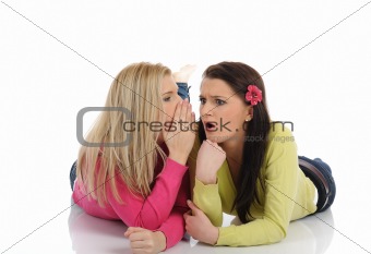 Two young pretty girls gossiping and enjoying conversation.