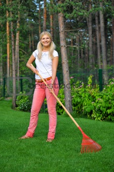 young pretty gardening woman with tools and rakes outdoors 