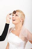 Professional wedding make-up is being applied to beautiful bride