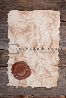 Old paper with a wax seal on wood texture 