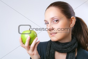 Beautiful young woman showing an apple